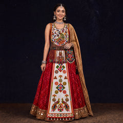 A woman modeling a heavily embroidered red and white traditional Indian outfit with a gold dupatta, set against a dark starry background.