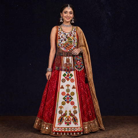 A woman modeling a heavily embroidered red and white traditional Indian outfit with a gold dupatta, set against a dark starry background.