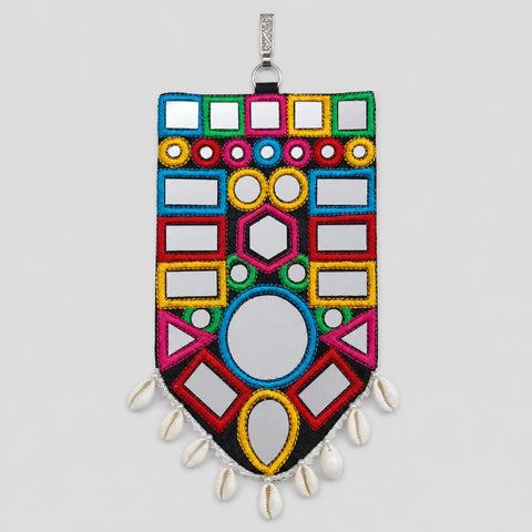 Kaudi Bharat | Option | A decorative rectangular wall mirror with colorful geometric embroidered borders, mirrored inset panels, white shell beads hanging from the bottom, and a silver hanging loop at the top, shown against a light gray background.