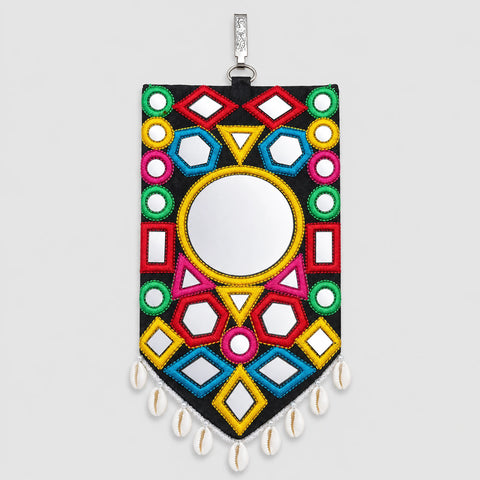 Suraj Bharat | Option | A rectangular wall mirror with a black background and colorful geometric beadwork, featuring a central circular mirror, hanging from a silver-toned loop with white cowrie shells at the bottom, shown against a light gray background.