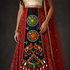 Black | A close-up of a model wearing a traditional Indian red and black lehenga choli with intricate multicolor embroidery, mirror work, and a red dupatta.