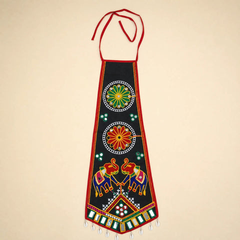 Black | A traditional Indian black cotton apron with red neck and waist ties, decorated with colorful hand-embroidered motifs including elephants, floral patterns, and geometric designs, set against a solid beige background.