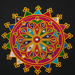 Rani Pink | A colorful embroidered circular patch with a mandala design, featuring yellow, magenta, blue, green, and white threadwork with small reflective mirror embellishments, set against a solid black background.
