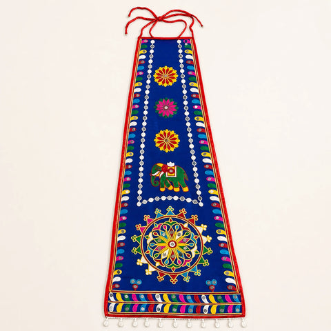 Blue | A vertical blue embroidered wall hanging or decorative banner with red ties at the top, multicolored floral and geometric motifs, and a small elephant design, shown against a plain light background.