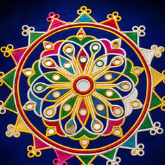 Blue | A close-up of a colorful embroidered circular mandala design on dark blue fabric, featuring yellow, pink, green, white, and red stitched patterns.