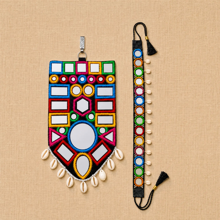 A colorful beaded mirror wall hanging and matching wrist strap set displayed on a beige textured fabric background. The set features geometric patterns with white mirrored squares, colorful bead borders in red, blue, green, yellow, and pink, white cowrie shells, and black tassels.